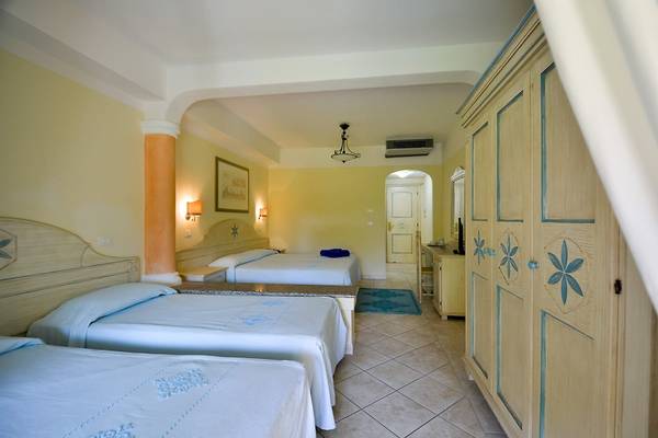 Schlafzimmer im Club Hotel Marina Beach mit drei Betten und gelben Wänden.
