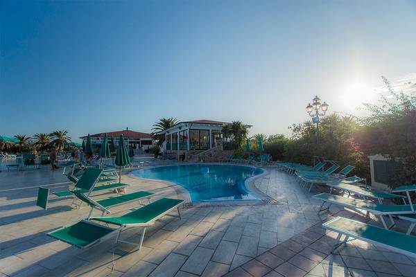 Poolbereich des Club Hotel Marina Beach mit Sonnenliegen und Sonnenschirmen.