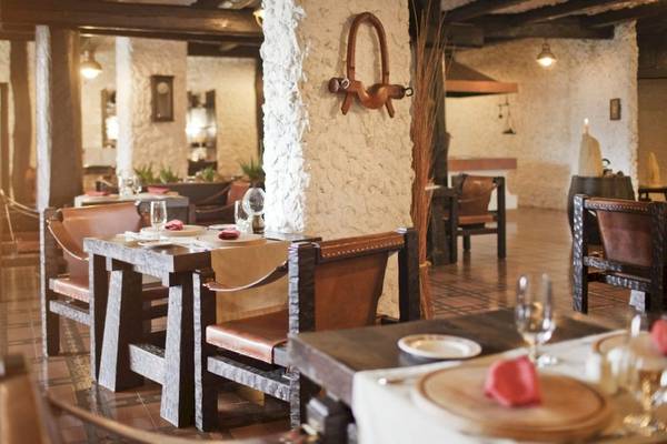 Innenansicht des Restaurants im Croatia Hotel mit gedeckten Tischen und rustikalem Dekor.
