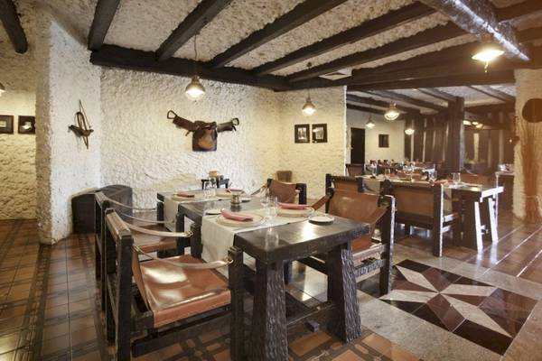 Innenbereich des Croatia Hotels Restaurant mit gedeckten Tischen und Lederstühlen.