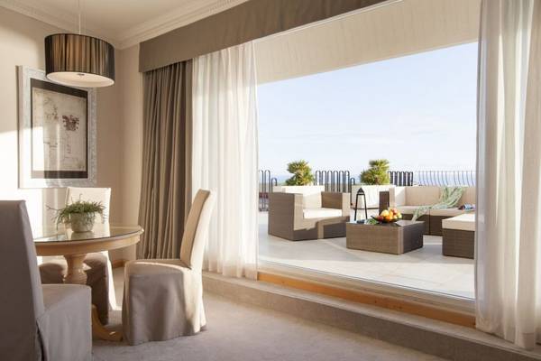 Innenansicht des Croatia Hotel Wohnbereich mit Aussicht auf eine Terrasse mit Möbeln.