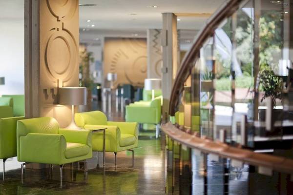 Empfangsbereich des Croatia Hotels mit hellgrünen Sesseln und einer Lampe.