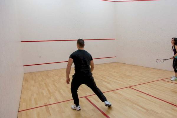 Ein Mann und eine Frau spielen Squash im AX Odycy Hotel.