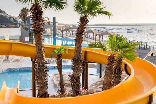 Wasserrutsche am Pool des AX Odycy Hotels mit Blick auf das Meer und Palmen