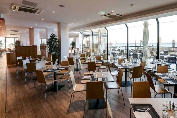 Innenansicht des Restaurants im AX Odycy Hotel mit Blick auf den Ozean.