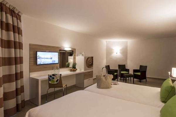 Doppelzimmer im AX Odycy Hotel mit zwei Betten, Schreibtisch und Fernseher.