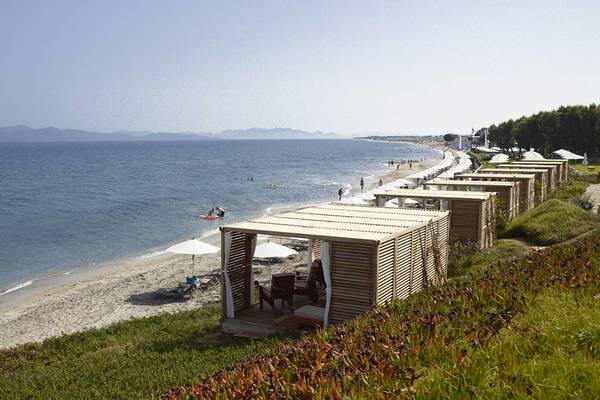 Außenansicht des Neptune Luxury Resort mit Strand, Wasser und Holzbungalows.