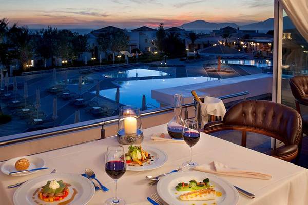 Abendessen auf der Terrasse des Neptune Luxury Resorts mit Blick auf den Pool und die Landschaft.