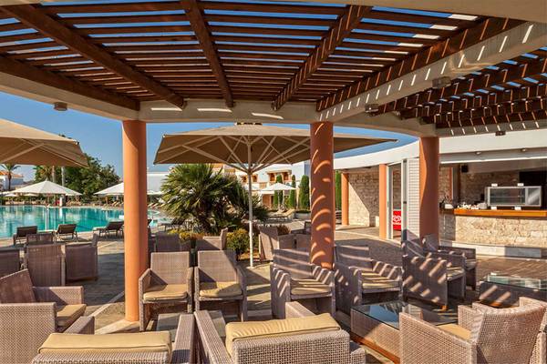 Pool-Lounge im Neptune Luxury Resort mit Sonnenschirmen und Stühlen