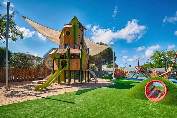 Kinderspielplatz im Neptune Luxury Resort mit grünem Spielturm, Rutsche und Sandfläche
