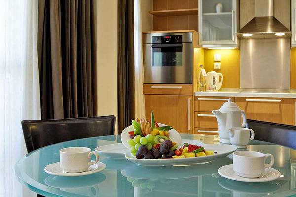 Essenbereich im Neptune Luxury Resort mit Obstplatte und Tassen auf einem Glastisch.