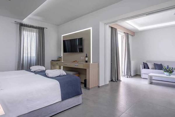 Schlafzimmer im Neptune Luxury Resort mit zwei Betten, Fernseher und Schreibtisch.