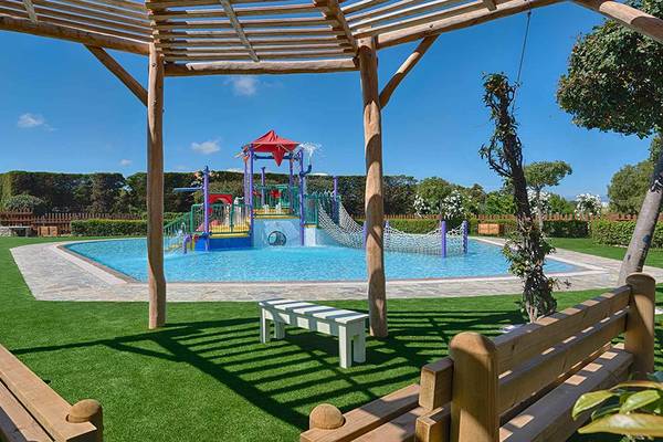 Außenbereich des Neptune Luxury Resort mit einem großen Spielplatz für Kinder.