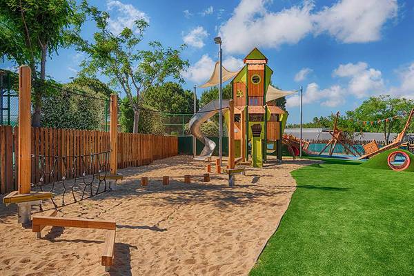 Ein kinderspielplatz im neptun luxus resort mit sand, rutsche und spielzeug.