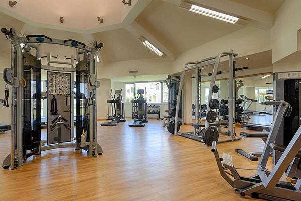 Fitness-Center im Neptun Luxus Resort mit verschiedenen Trainingsgeräten auf Holzboden.