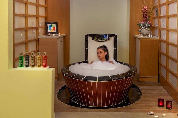 Eine Frau genießt ein Bad in der Jacuzzi-Suite im Neptune Luxury Resort.