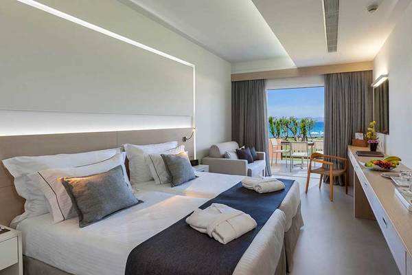 Hotelzimmer im Neptune Luxury Resort mit Blick auf den Ozean und moderner Einrichtung.