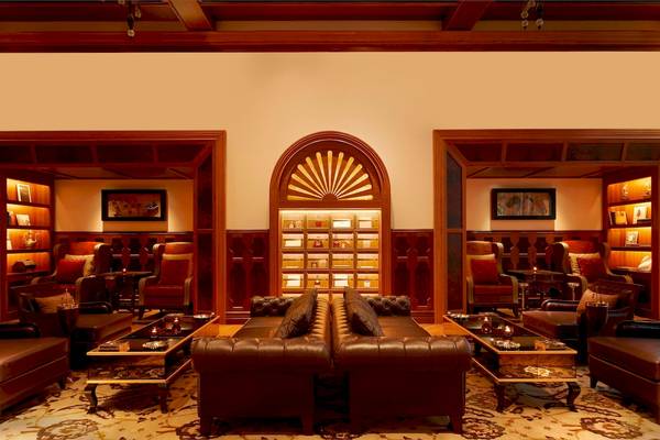 Innenansicht des St. Regis Abu Dhabi Lounge mit zwei Ledersofas, Beistelltischen und hängenden Lampen.