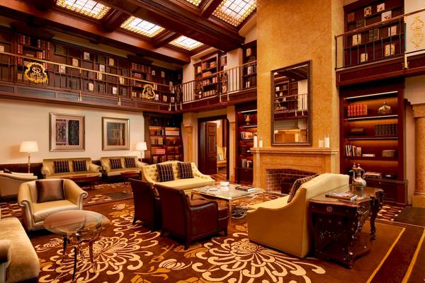 Bibliothek-Lounge im St. Regis Abu Dhabi Hotel mit Möbeln und Bücherregalen.