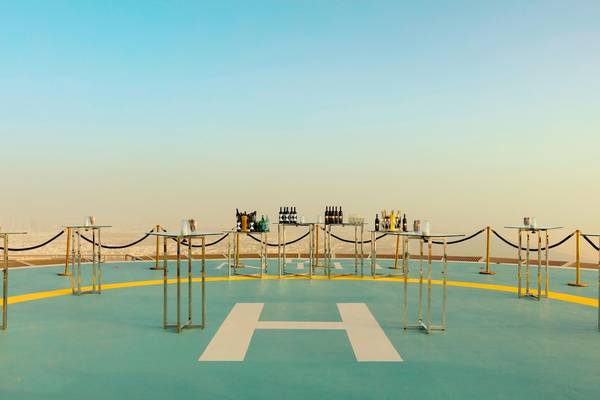 Helipad-Dessert-Arrangement im St. Regis Abu Dhabi mit gedeckten Tischen und Flaschen.