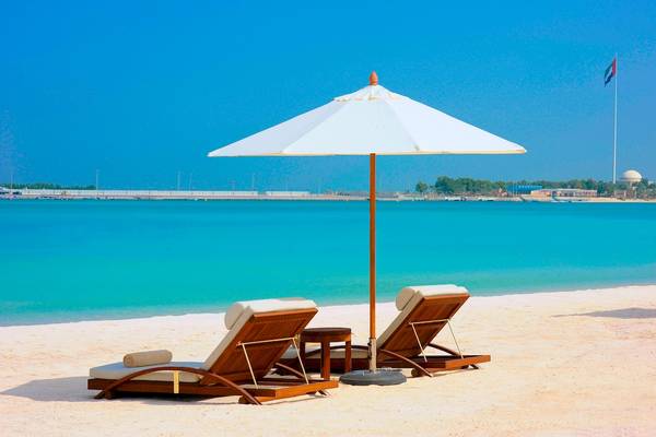 Strand mit Liegen und Schirm im St. Regis Abu Dhabi