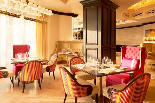Das St. Regis Abu Dhabi Hotel zeigt den Innenbereich des Restaurants mit farbigen Stühlen und Tischen.