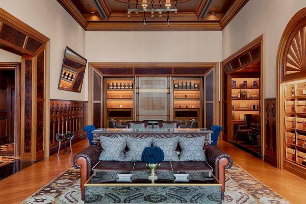 Loungebereich im St. Regis Abu Dhabi Hotel mit Ledersofa, Glastisch und Regalen.
