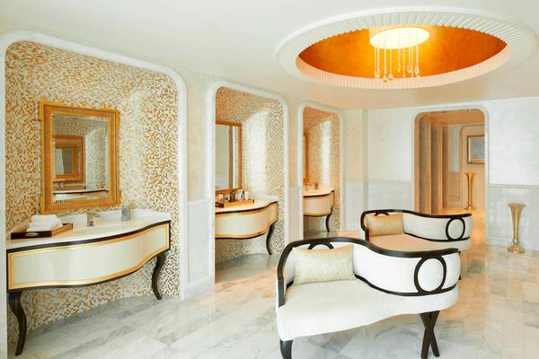 Luxuriöses Badezimmer im St. Regis Abu Dhabi mit goldenen Akzenten und Marmorfliesen.