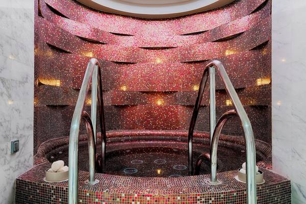 Innenpool im St. Regis Abu Dhabi Hotel mit roten Mosaiken und Marmorboden.