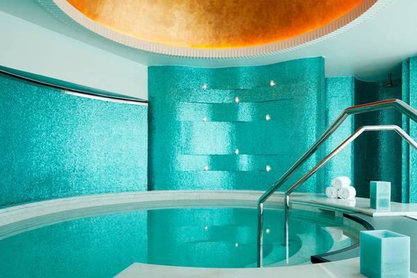 Der Pool im St. Regis Abu Dhabi mit türkisblauen Wänden und einer runden, goldenen Decke.
