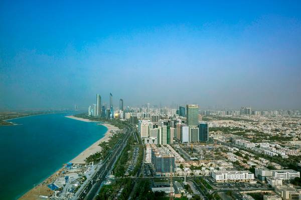 Hochueblicher Blick auf die Stadt Abu Dhabi mit vielen Gebäuden und einer Küste.