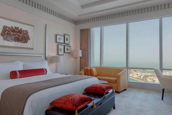 Suite im St. Regis Abu Dhabi mit großem Bett, Sofa und Meerblick.
