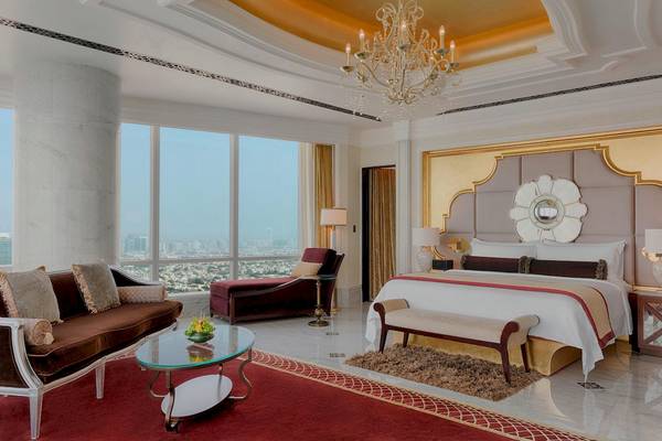 Luxuriöse Suite im St. Regis Abu Dhabi mit großem Bett, Wohnzimmer und Blick auf die Stadt.