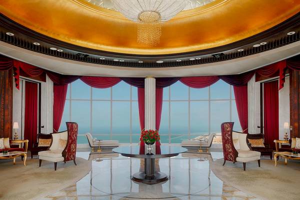 Loungebereich im St. Regis Abu Dhabi mit großem Fenster und rotem Vorhang.