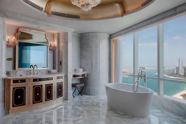 Badezimmer im St. Regis Abu Dhabi mit Blick auf das Meer und eine Stadt.
