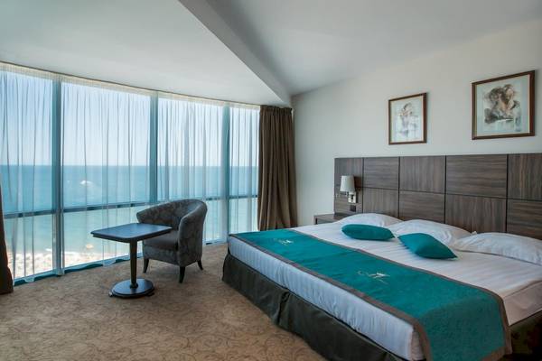 Hotelzimmer des Marina Grand Beach mit Meerblick, inklusive Bett, Tisch, Stuhl und Fernseher.