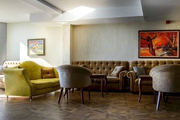 Lobby-Lounge im Marina Grand Beach Hotel mit Sofas, Sesseln und Gemälden an der Wand.