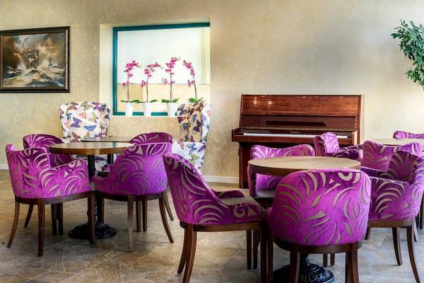 Loungebereich im Marina Grand Beach Hotel mit Klavier, Stühlen und Tisch