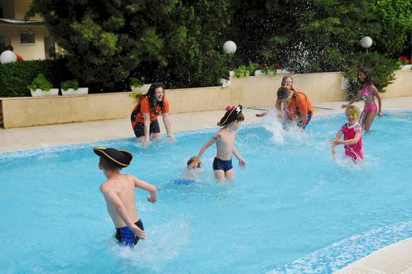 Kinder spielen im Pool des Marina Grand Beach Hotels, einige tragen Piratenkostüme.