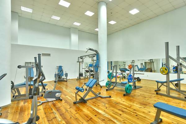 Fitnessstudio im Marina Grand Beach Hotel mit verschiedenen Trainingsgeräten und einem großen Spiegel.