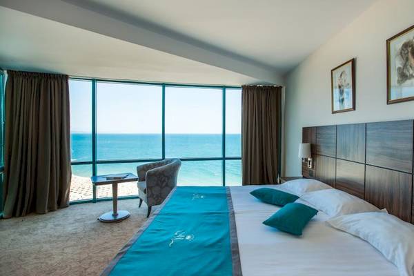 Zimmer im Marina Grand Beach Hotel mit Blick auf das Meer und zwei Betten