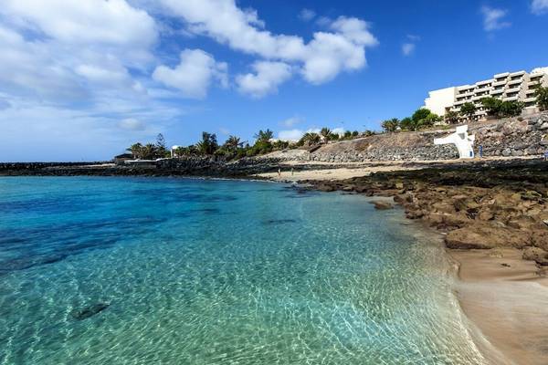 Barcelo Lanzarote Active Resort am Strand mit blauem Wasser und felsiger Küste