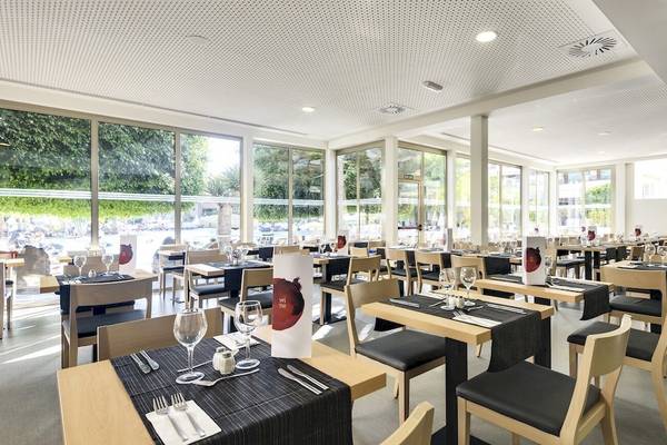 Innenansicht des Restaurants im Barcelo Lanzarote Active Resort mit vollen Tischen und Stühlen.