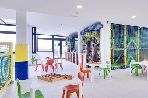 Kinderspielbereich im Barcelo Lanzarote Active Resort mit bunten Tischen und Stühlen und einer Kletterwand.