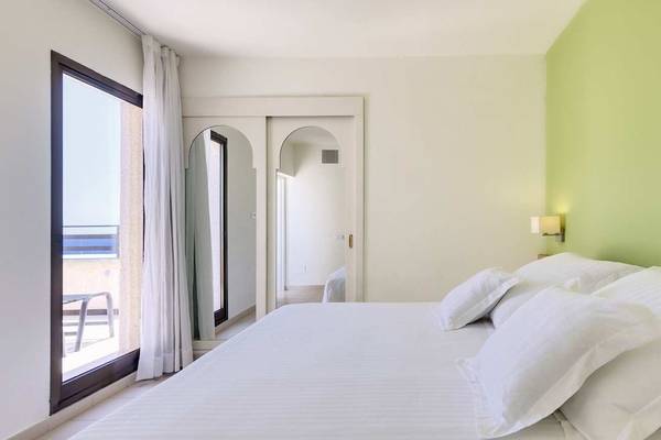 Schlafzimmer im Barcelo Lanzarote Active Resort mit einem großen Bett und vielen Kissen.