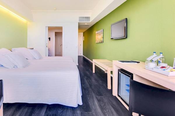 Zimmer im Barcelo Lanzarote Active Resort mit zwei Betten, grünen Wänden und modernem Interieur.