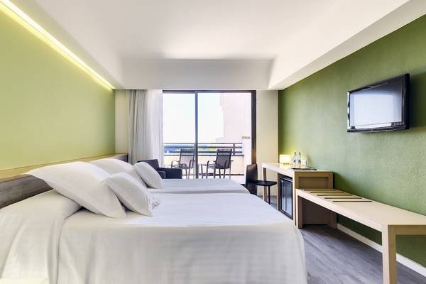 Zimmer im Barcelo Lanzarote Active Resort mit zwei Betten, Fernseher, Balkon und Möbeln.