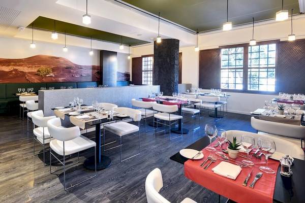 Innenbereich des Restaurants im Barcelo Lanzarote Active Resort mit gedeckten Tischen und Stühlen.