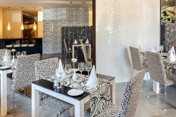 Innenansicht des Restaurants im Barcelo Lanzarote Active Resort mit geschwungenen Mustern auf den Stühlen und Tischen.
