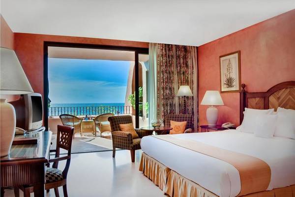 Hotelzimmer mit Meerblick im Tivoli La Caleta Tenerife Resort, mit Balkon, Bett, Schreibtisch und Aussicht auf das Meer.